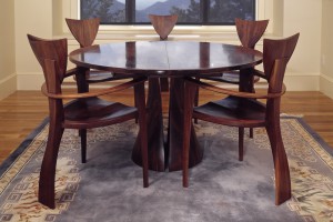Round walnut dining table with Finback armchairs and expanding table by Seth Rolland custom furniture design