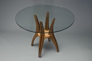 Round glass top wood dining cafe table with curved sculpted legs by Seth Rolland custom furniture design