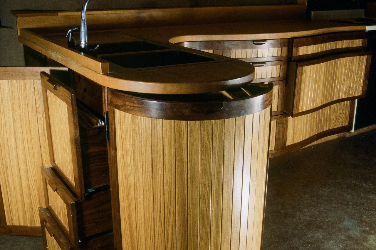 Curved kitchen with doors and drawers open by Seth Rolland custom furniture design