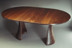 Expanding oval wood dining table in solid walnut by Seth Rolland custom furniture design