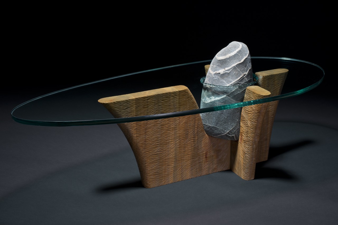 Stone and wood coffee table hand carved with a glass top by Seth Rolland Custom Wood Furniture